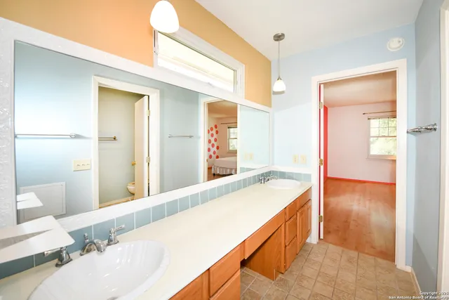 a spacious bathroom with a granite countertop sink and a mirror