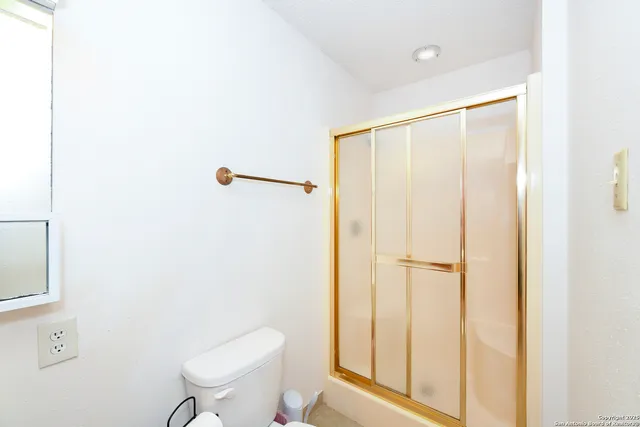 a bathroom with a toilet a sink and shower