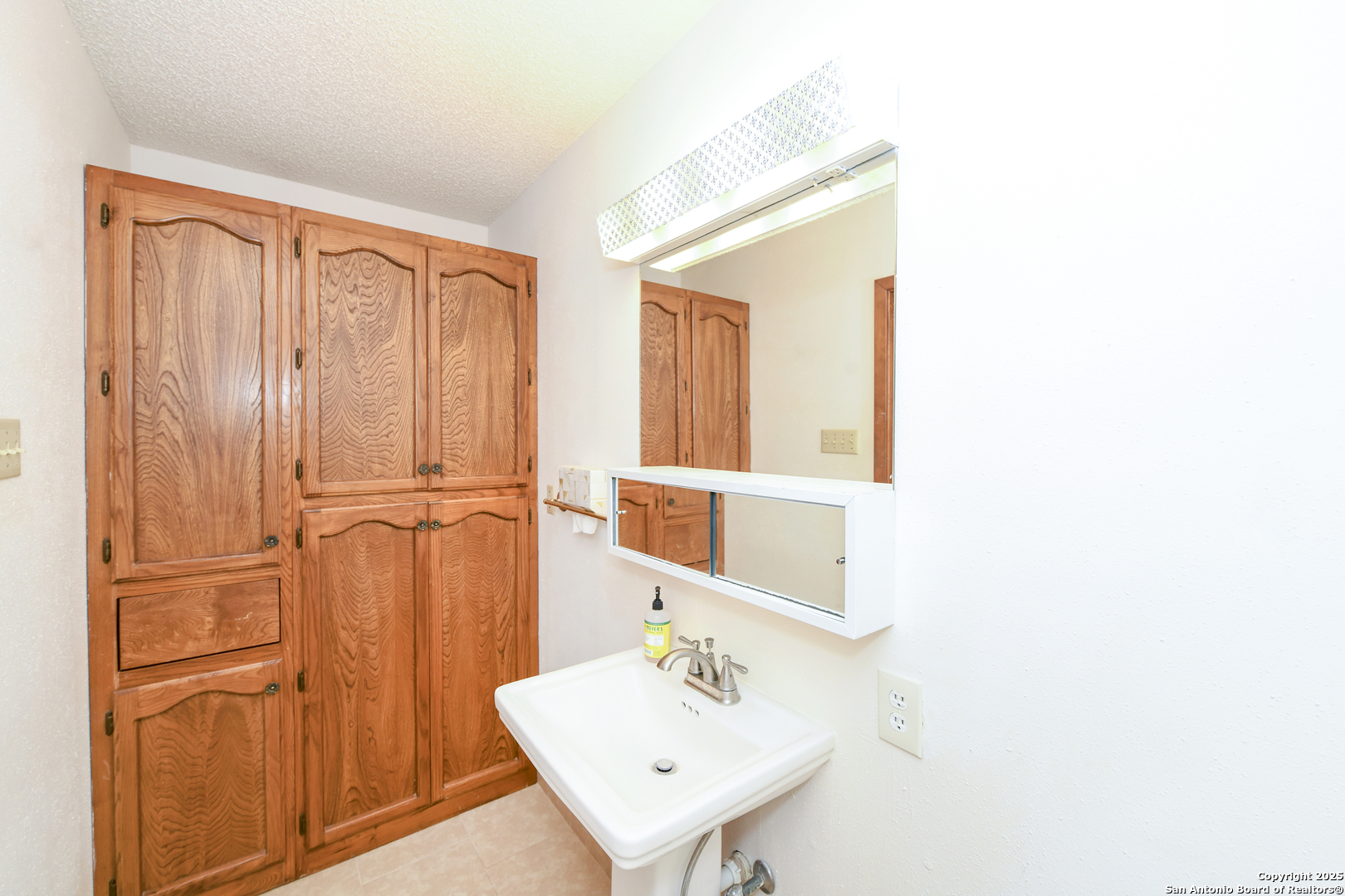 5803 Hollyhock Road San Antonio, TX 78240 - Photo 30 of 51 a bathroom with a sink a mirror and a shower