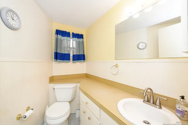 a bathroom with a sink a toilet and a mirror