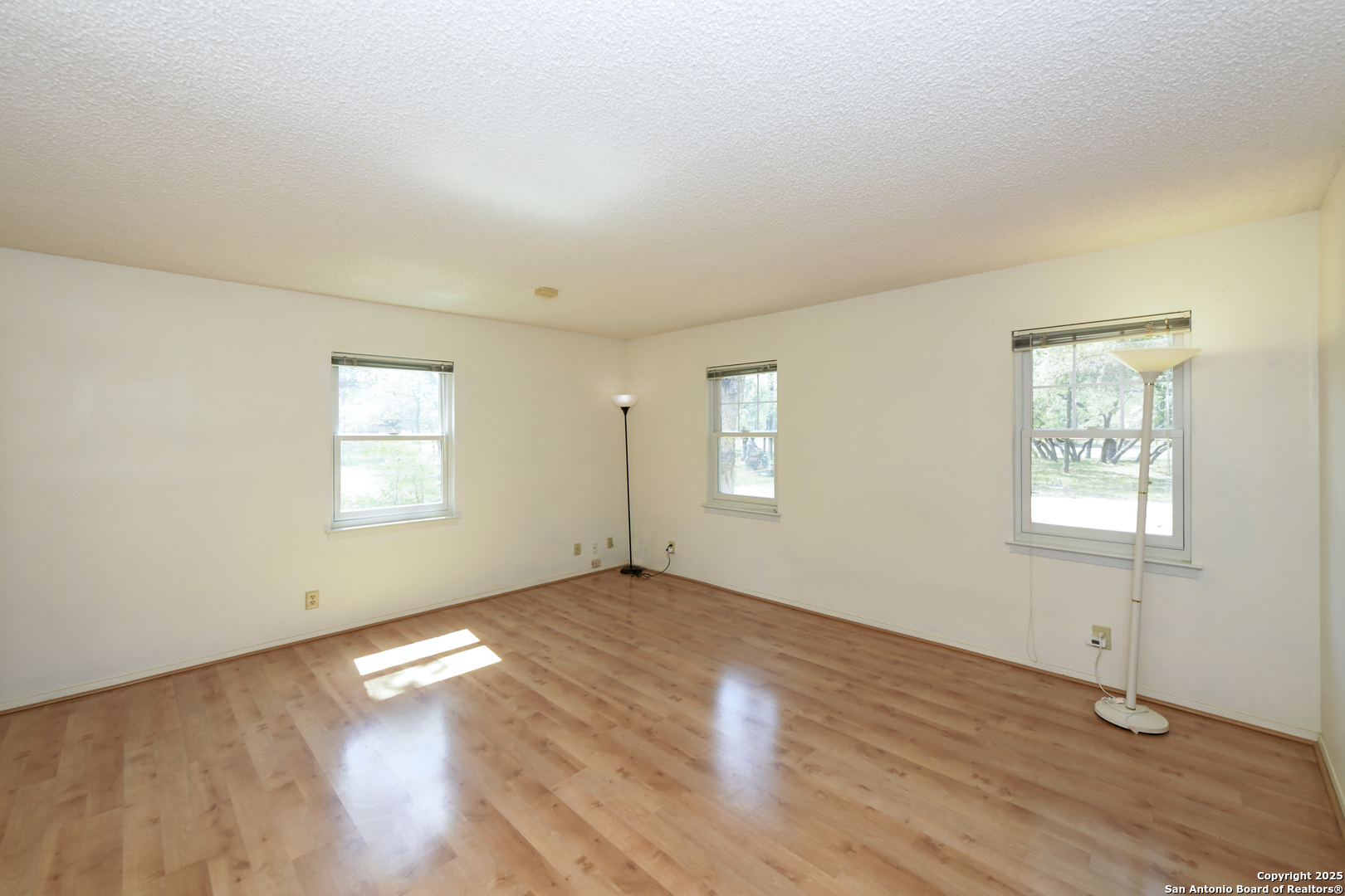 5803 Hollyhock Road San Antonio, TX 78240 - Photo 38 of 51 an empty room with wooden floor and windows