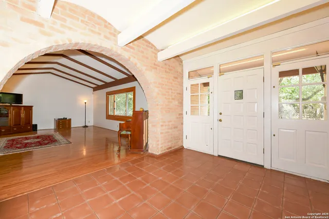 a view of empty room with wooden floor and a window