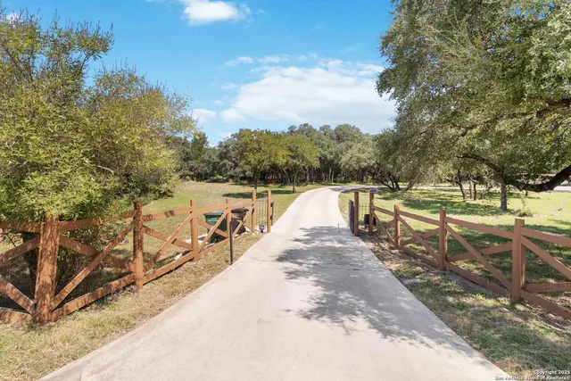 a view of a lake with a bench under large trees