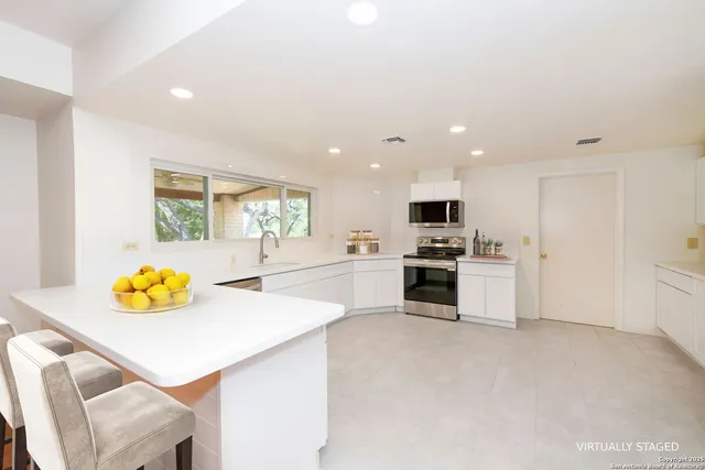 a kitchen with stainless steel appliances kitchen island sink refrigerator and stove