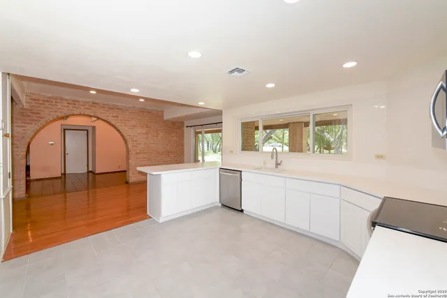 a large white kitchen with a large window