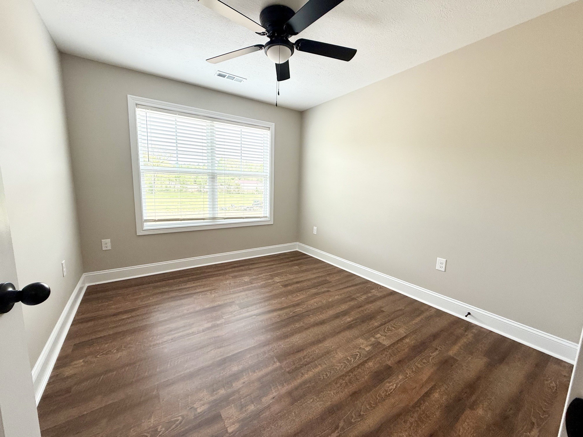 80 Ridge Road, Unit B Waverly, TN 37185 - Photo 6 of 11 an empty room with wooden floor chandelier fan and windows