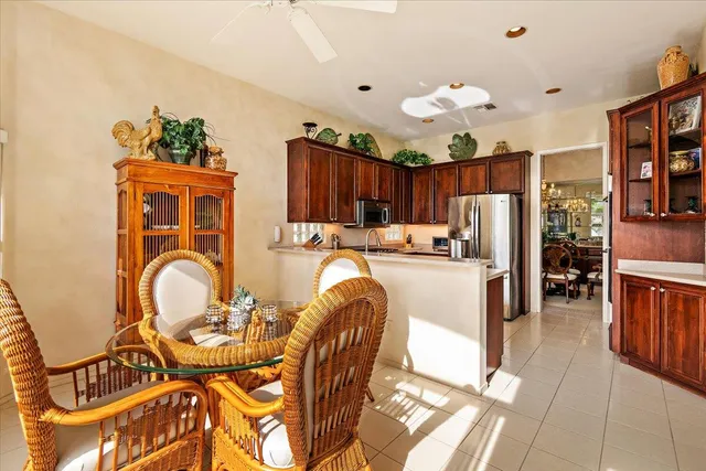 a kitchen with stainless steel appliances granite countertop a stove a refrigerator and a dining table with wooden floor