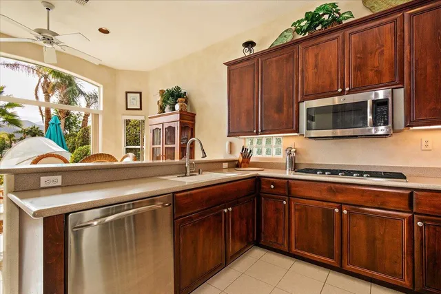 a kitchen with stainless steel appliances granite countertop wooden cabinets a stove top oven a sink and dishwasher