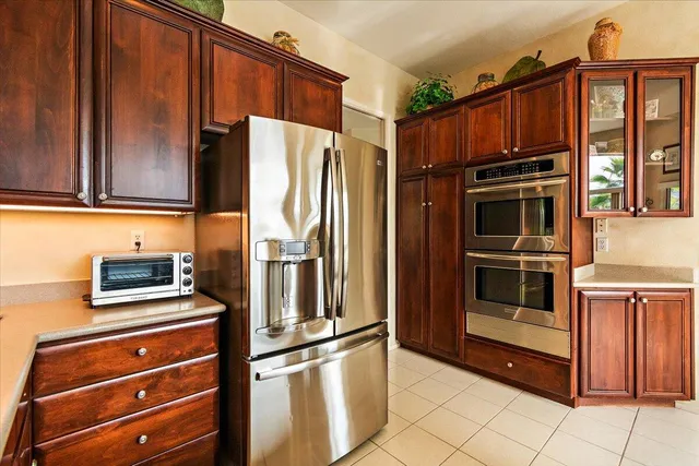 a kitchen with stainless steel appliances granite countertop a refrigerator and a stove top oven