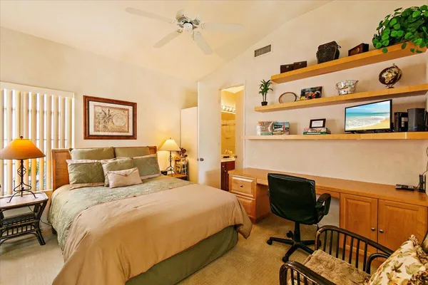 a bedroom with a bed a table and chair
