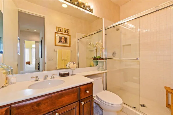 a bathroom with a sink a toilet a mirror and shower