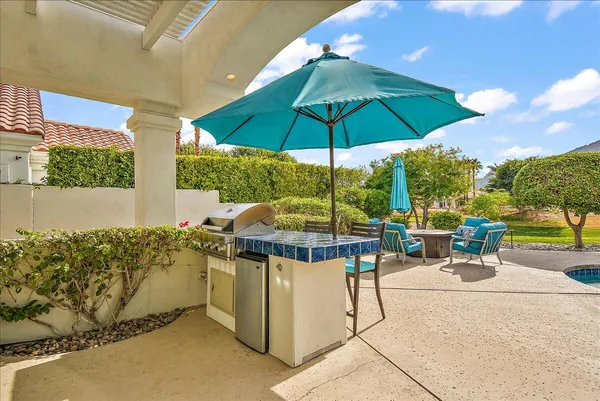 a view of a patio with a table and chairs under an umbrella