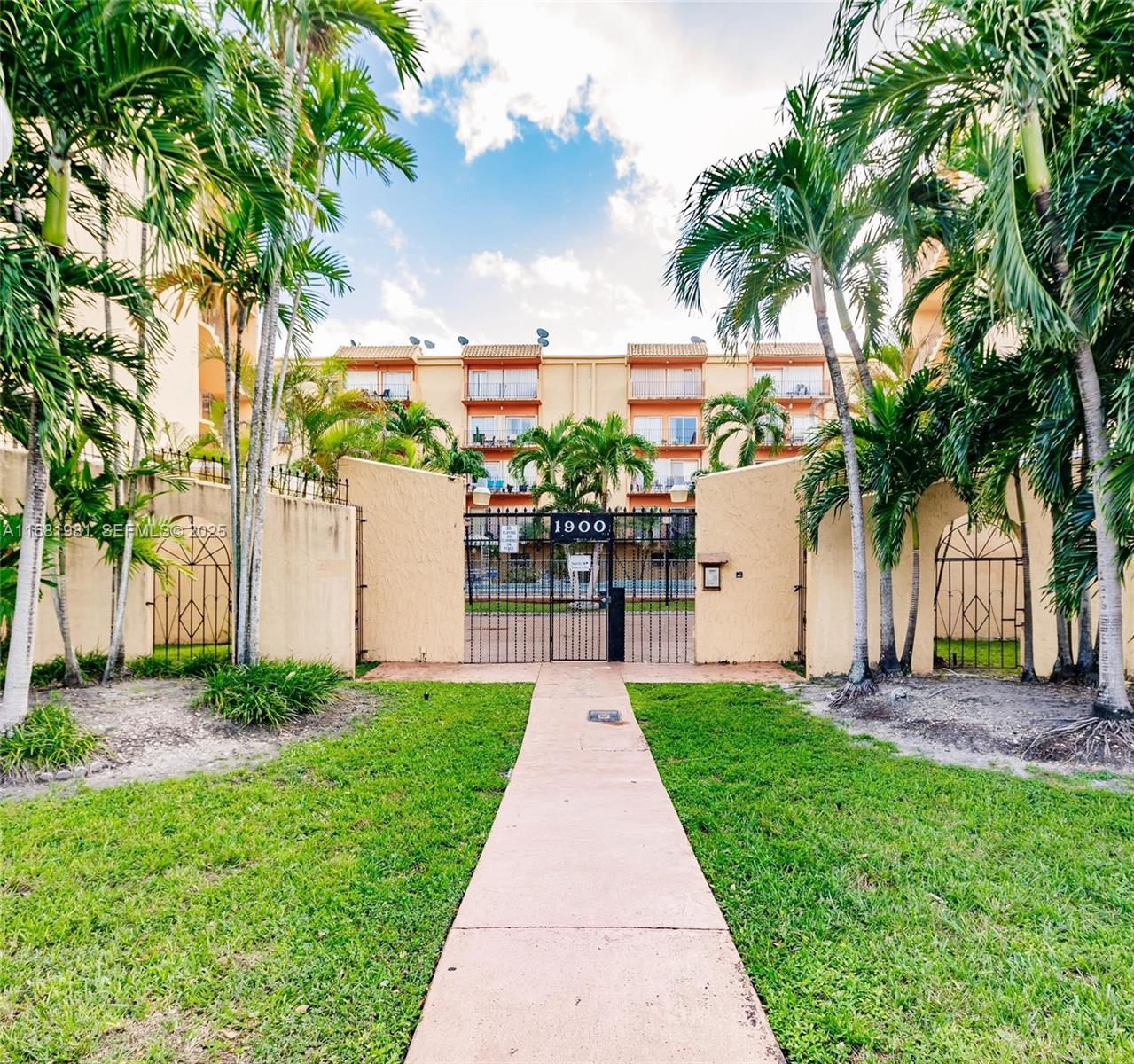 1900 West 54th Street, Unit 213 Hialeah, FL 33012 - Photo 3 of 21 a front view of a house with a yard and potted plants
