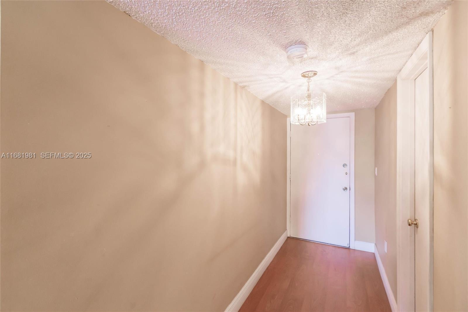 1900 West 54th Street, Unit 213 Hialeah, FL 33012 - Photo 6 of 21 wooden floor in a hall with a window