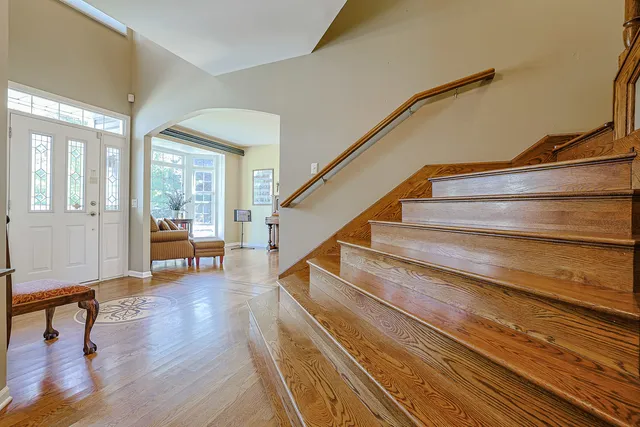 a living room with wooden floor and a potted plant on a table