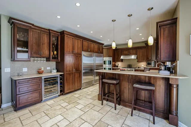 a kitchen with kitchen island granite countertop wooden cabinets and stainless steel appliances