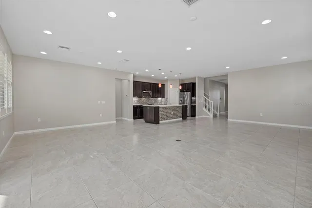 a view of empty room with wooden floor and windows