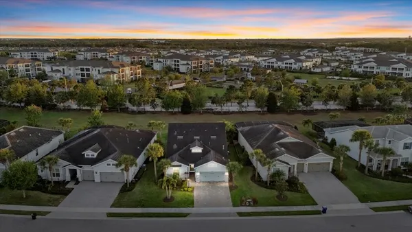 an aerial view of residential houses with outdoor space and swimming pool