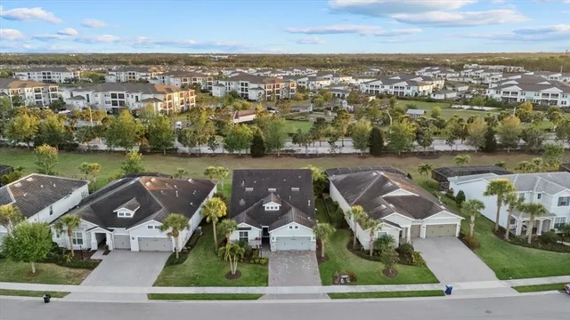an aerial view of residential houses with outdoor space and lake view