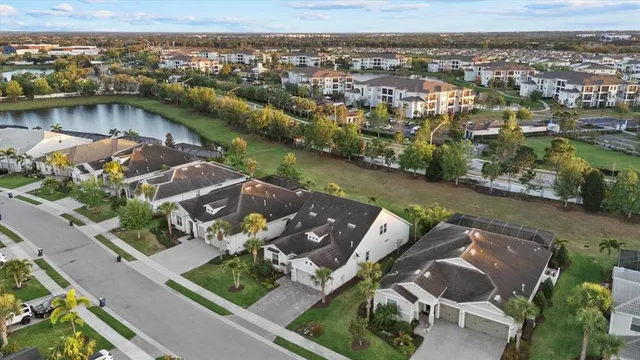 an aerial view of a residential houses with outdoor space and parking
