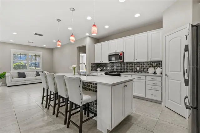a kitchen with granite countertop white cabinets and stainless steel appliances