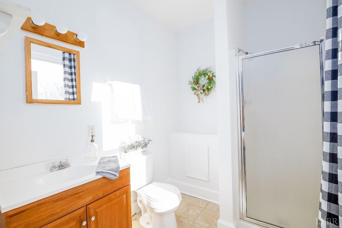 3655 Lowry Road Goode, VA 24556 - Photo 20 of 46 a bathroom with a sink mirror vanity and toilet