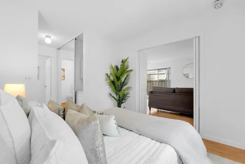 a bedroom with a bed and a potted plant