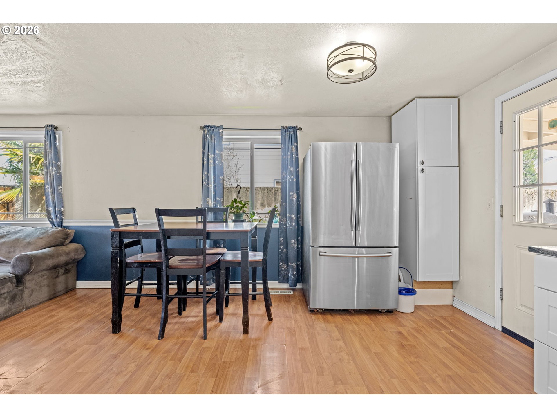 402 Clover Street Aumsville, OR 97325 - Photo 13 of 26 a kitchen with stainless steel appliances granite countertop a refrigerator a stove a dining table and chairs with wooden floor