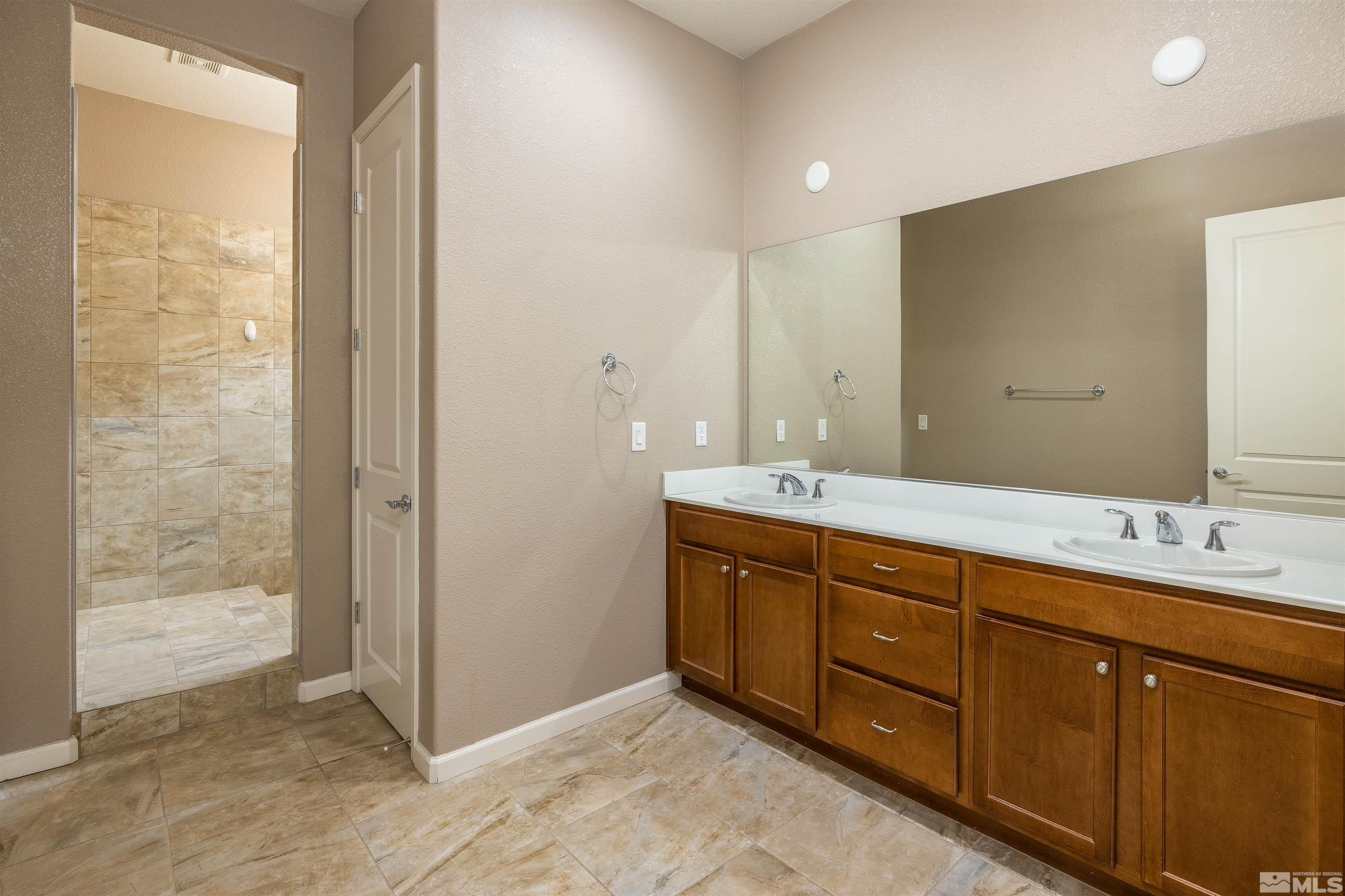 2113 Gregorgio Reno, NV 89521 - Photo 13 of 27 a spacious bathroom with a double vanity sink and a mirror