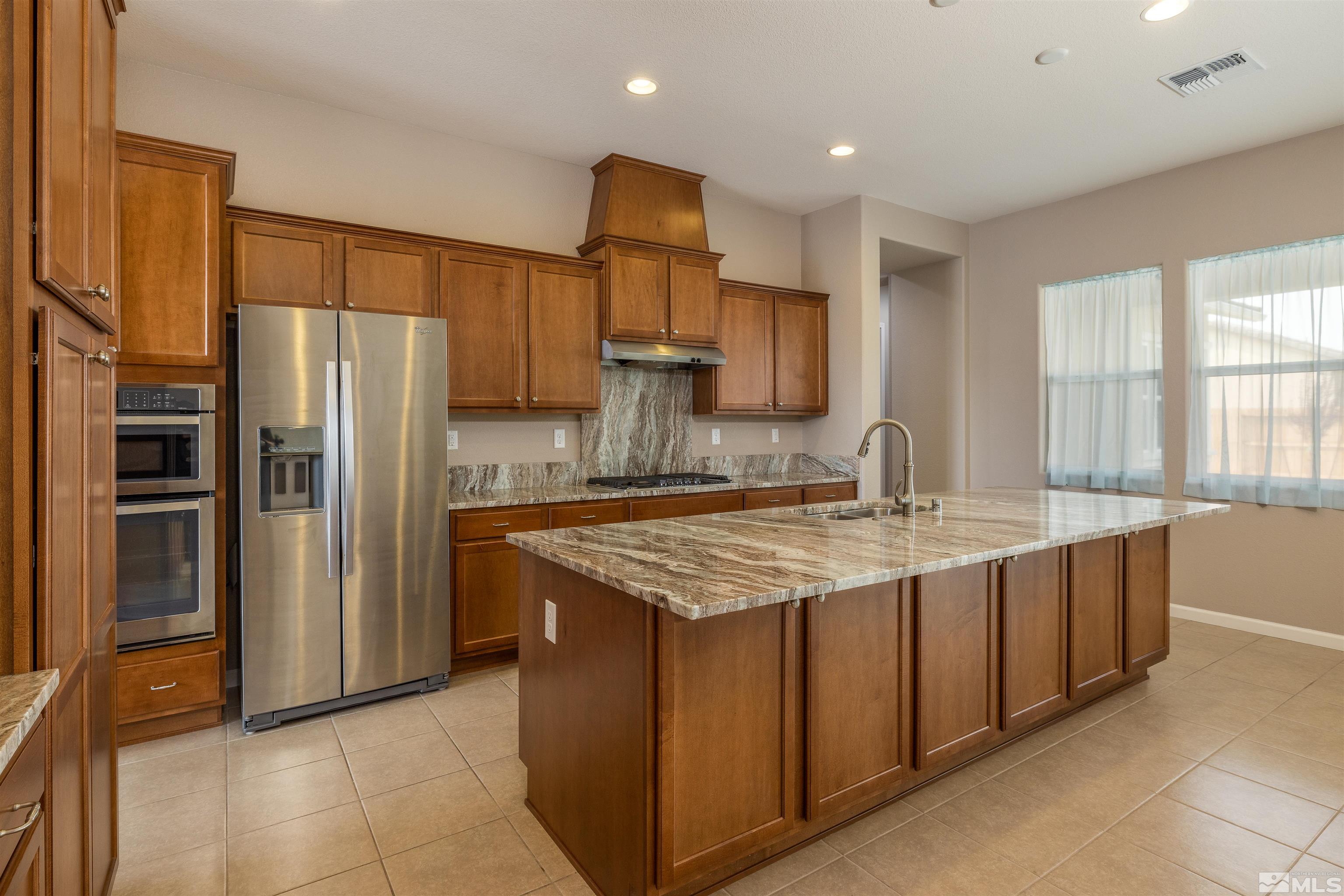 2113 Gregorgio Reno, NV 89521 - Photo 6 of 27 a kitchen with stainless steel appliances granite countertop a refrigerator a sink and a stove
