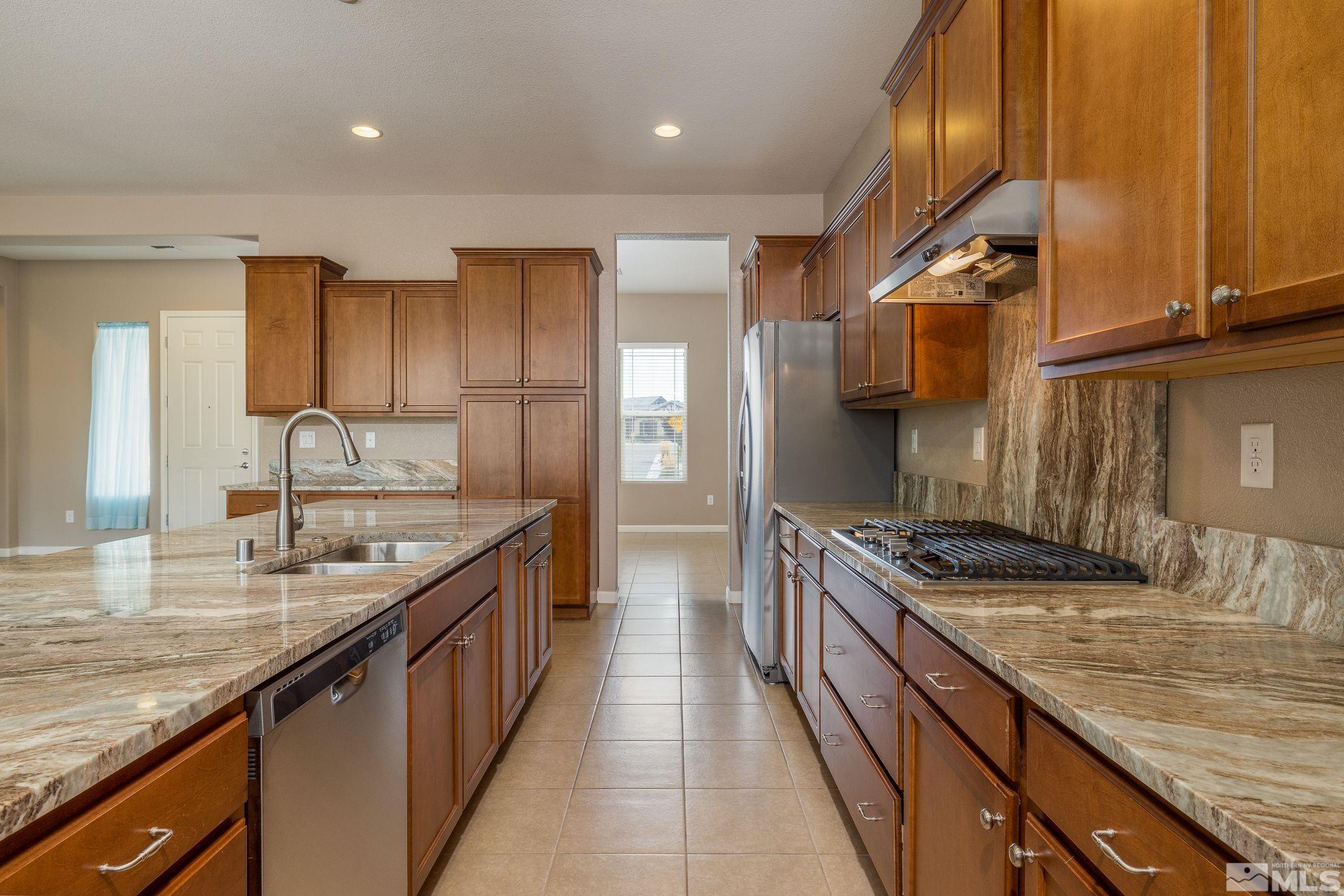 2113 Gregorgio Reno, NV 89521 - Photo 8 of 27 a kitchen with granite countertop kitchen island stainless steel appliances a sink stove top oven and cabinets