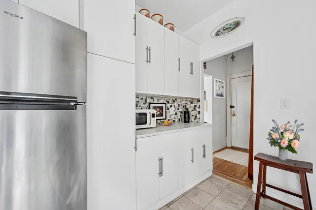 a hallway with white cabinets and wooden floor