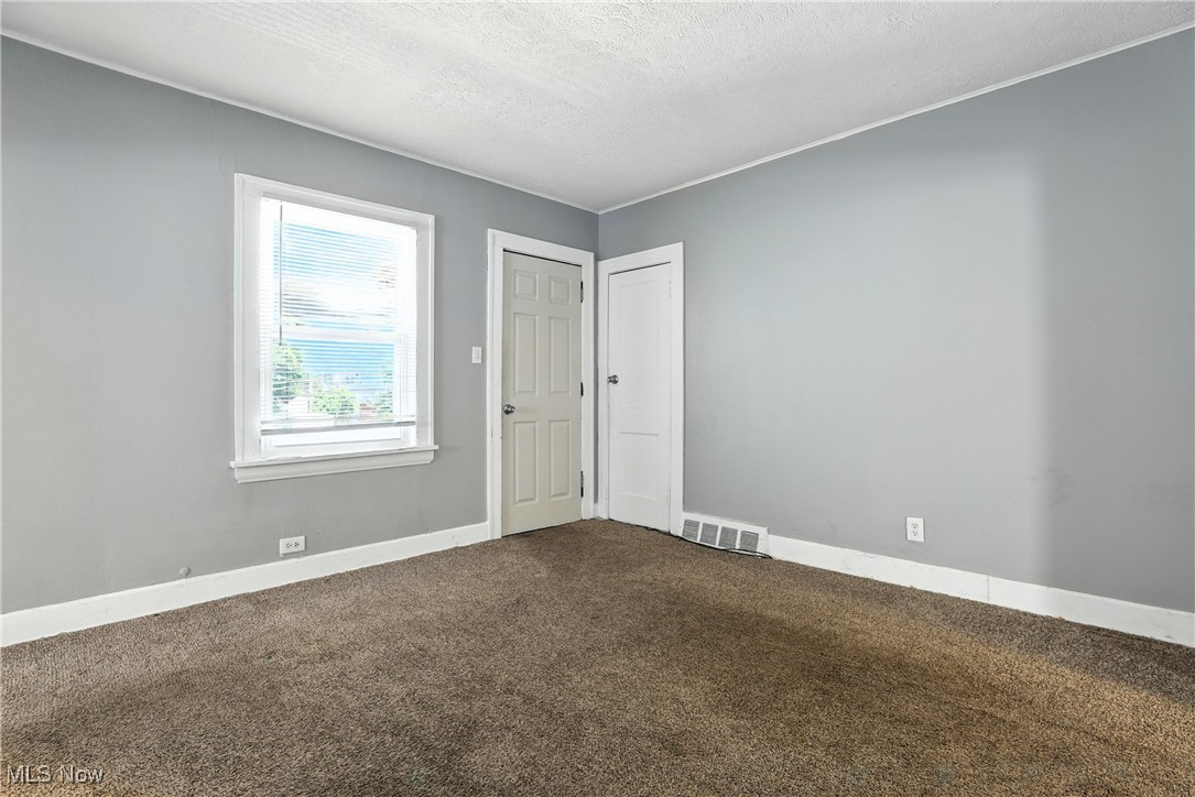 1774 Urbana Road Cleveland, OH 44112 - Photo 18 of 41 Spare room featuring dark carpet and a textured ceiling