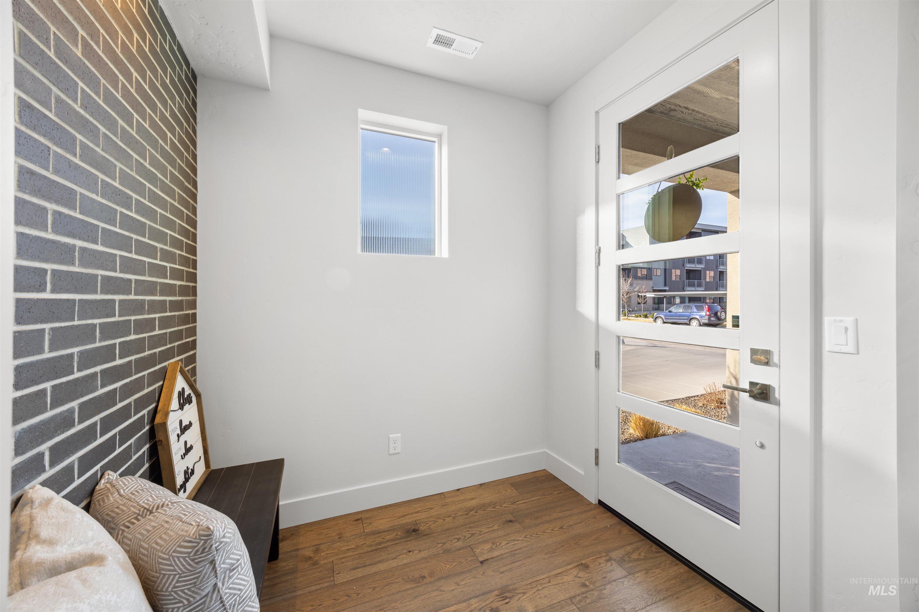 3282 South Millbrook Way Boise, ID 83716 - Photo 2 of 45 Living area featuring dark wood-type flooring and brick wall