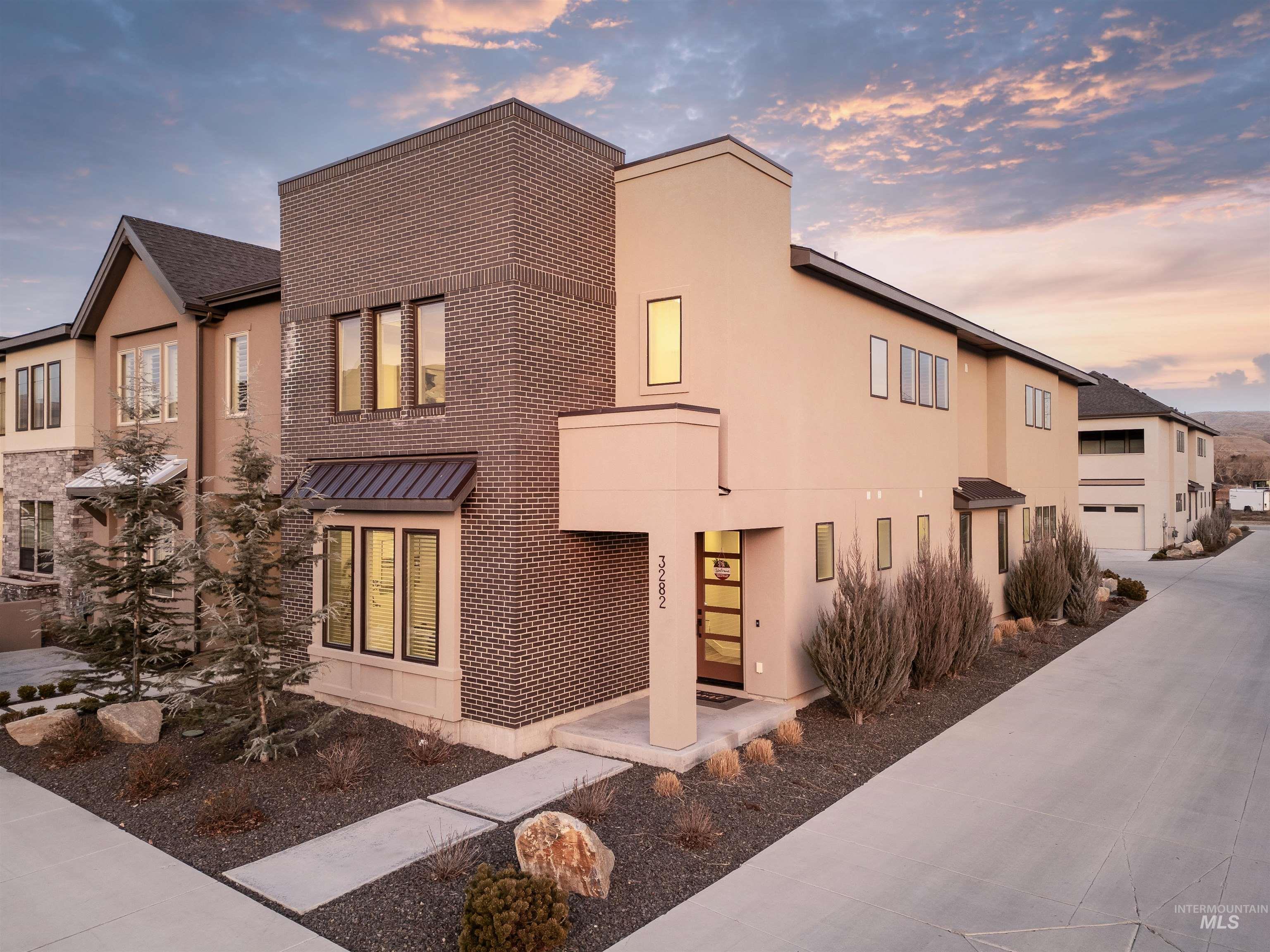3282 South Millbrook Way Boise, ID 83716 - Photo 43 of 45 View of front of property featuring brick siding, concrete driveway, stucco siding, and a standing seam roof