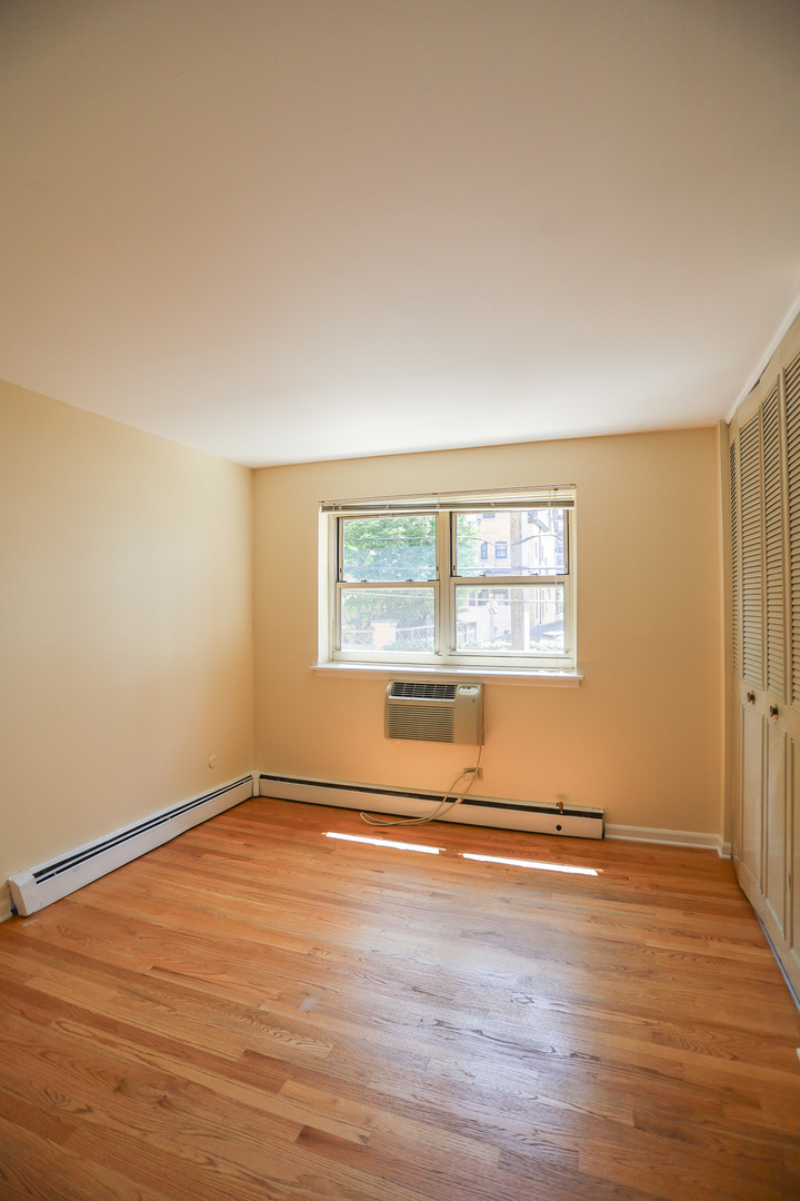 521 West Briar Place, Unit 201 Chicago, IL 60657 - Photo 6 of 9 a view of an empty room with wooden floor and a window