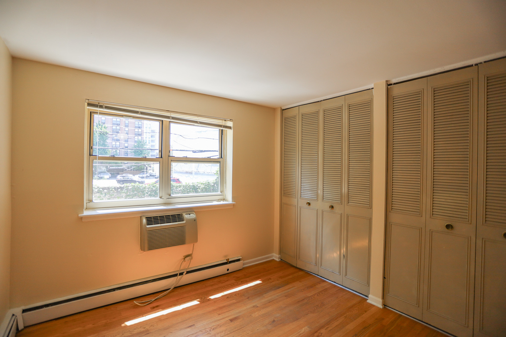 521 West Briar Place, Unit 201 Chicago, IL 60657 - Photo 7 of 9 a view of an empty room with wooden floor and a window