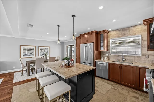 a open kitchen with stainless steel appliances granite countertop a stove a sink a dining table and chairs