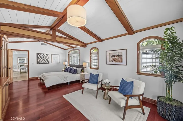 a spacious bedroom with a bed and a chair with the wooden floor