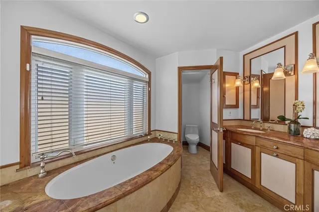 a bathroom with a granite countertop sink and a bathtub