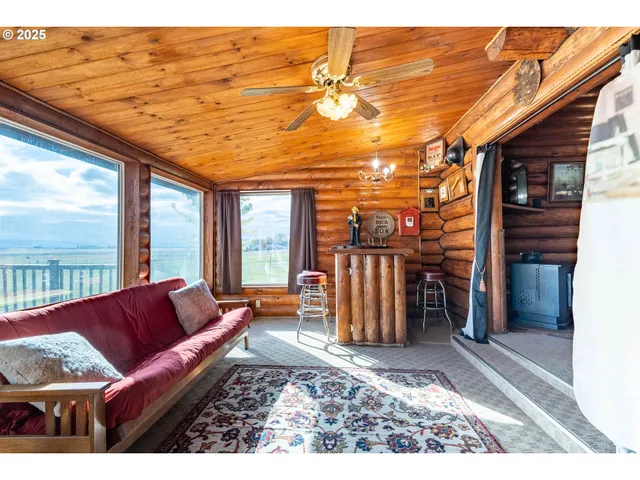 a living room with furniture a flat screen tv and floor to ceiling window