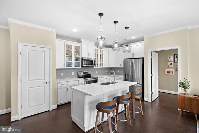 a kitchen with a dining table chairs refrigerator and cabinets