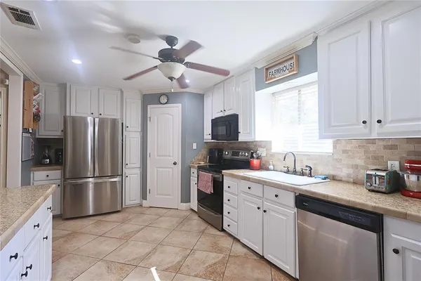 a kitchen with stainless steel appliances granite countertop a sink and dishwasher a stove top oven with wooden floor