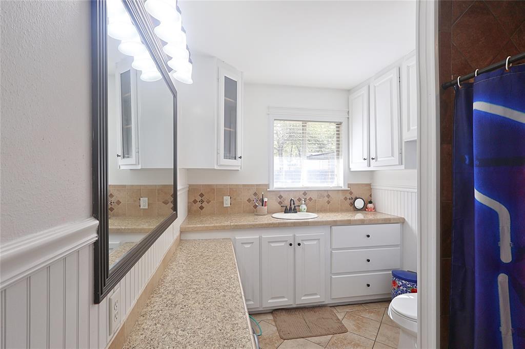 505 Colonial Drive Athens, TX 75751 - Photo 17 of 33 a bathroom with a double vanity sink a toilet and a bathtub