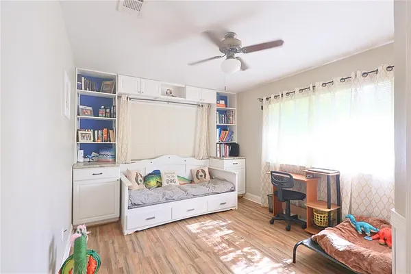 a bedroom with a bed and wooden floor
