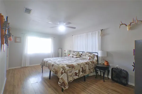 a bedroom with a bed and wooden floor