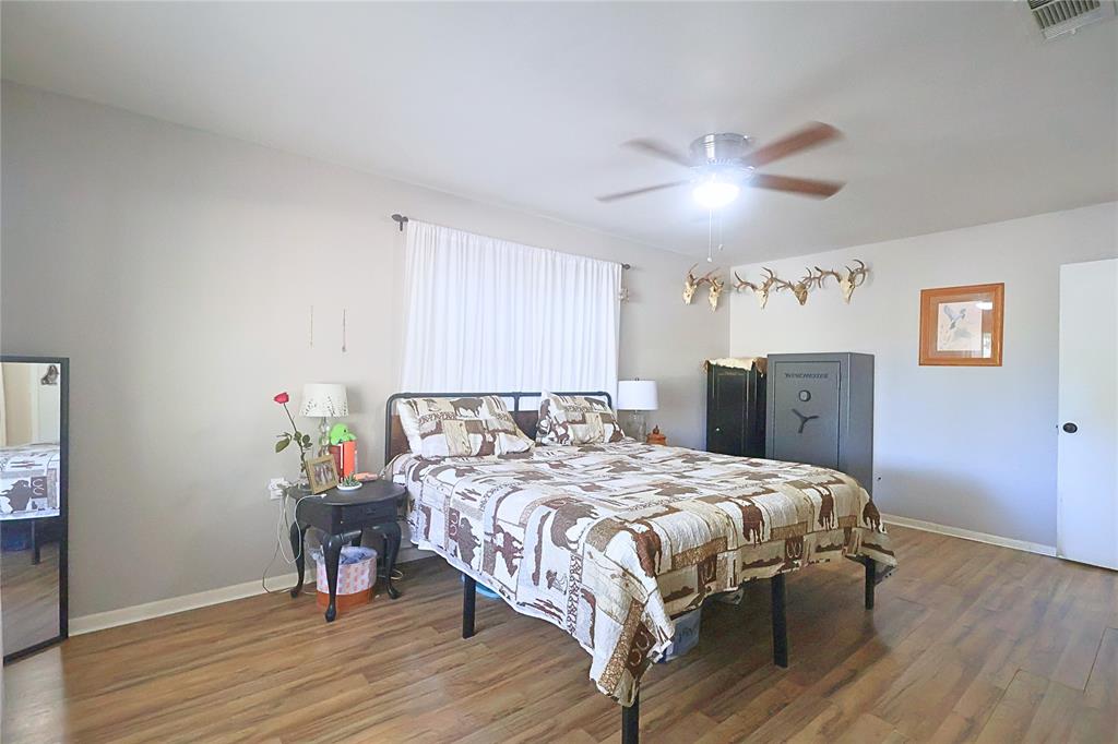 505 Colonial Drive Athens, TX 75751 - Photo 23 of 33 a bedroom with a bed and wooden floor