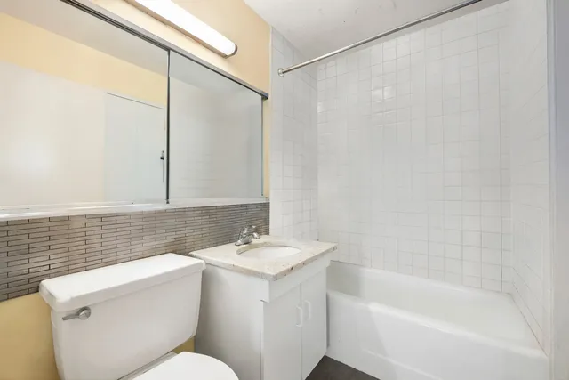 a bathroom with a sink mirror vanity and toilet