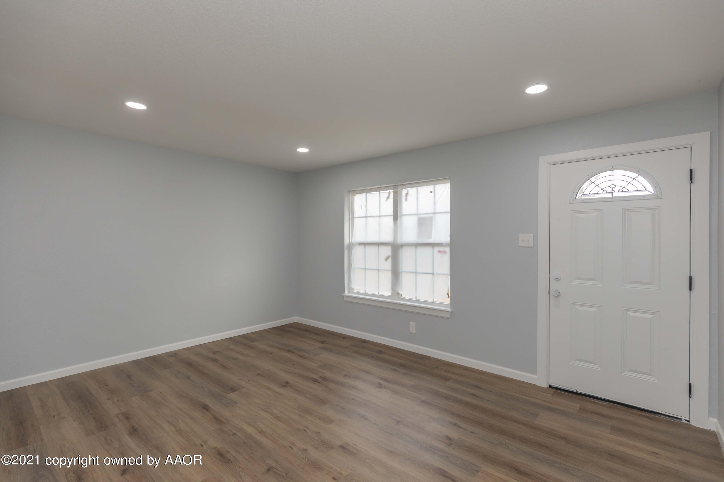 3808 Gables Street Amarillo, TX 79110 - Photo 2 of 23 an empty room with wooden floor and windows