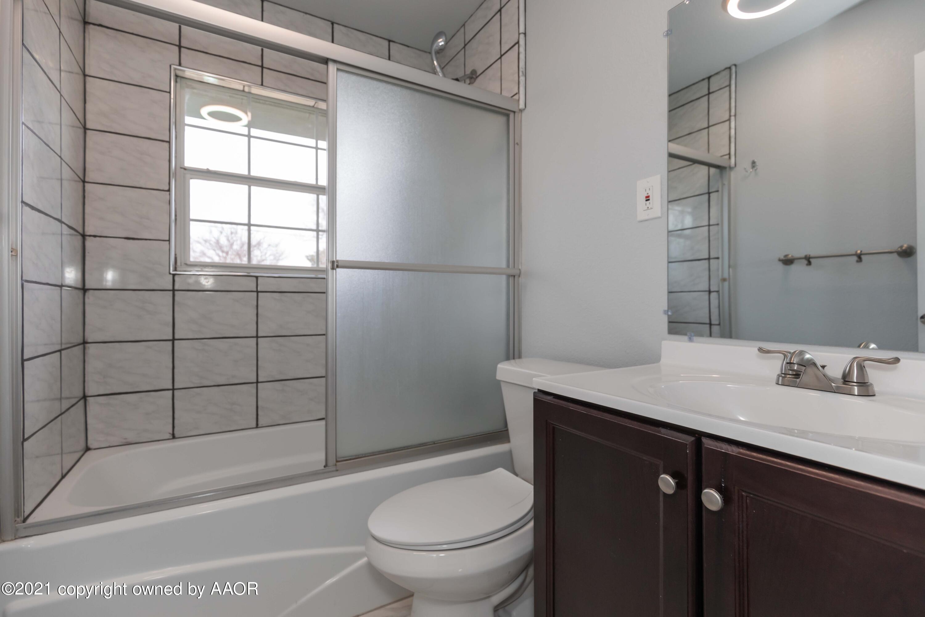 3808 Gables Street Amarillo, TX 79110 - Photo 13 of 23 a bathroom with a granite countertop sink toilet and shower